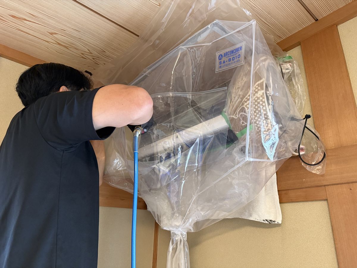 室内を養生してエアコン内部を高圧洗浄する空間Dr.のスタッフ